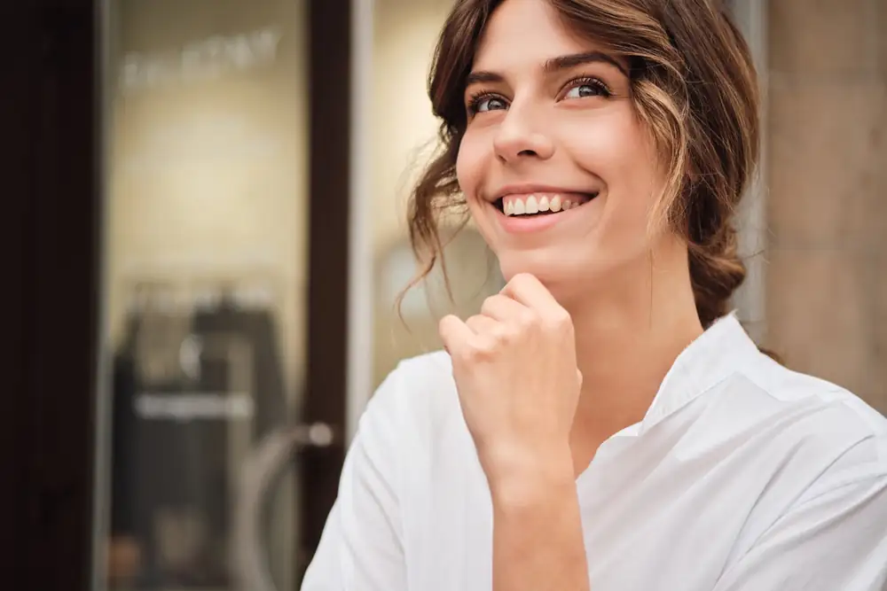 Mulher sorrindo com confiança em um ambiente do dia a dia